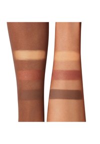 Échantillons de maquillage sur deux bras, présentant diverses teintes neutres et chaudes en finitions crème et mate, allant du beige doux au brun profond.