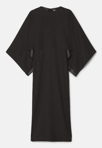 Longue robe noire avec de larges manches style cape et un col rond haut, suspendue sur un fond clair uni.