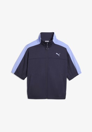 Donkerblauw jack met lichtblauwe korte mouwen en hoge kraag, voorzien van een volledige ritssluiting aan de voorkant en een wit Puma-logo op de borst. Twee zijzakken.