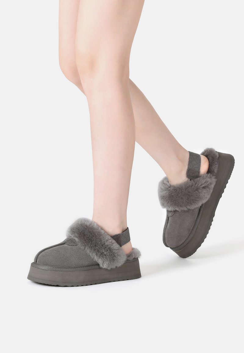 Gray suede platform sandals with a fluffy gray fur trim and adjustable back strap. Soft texture, rounded design, and sturdy sole.