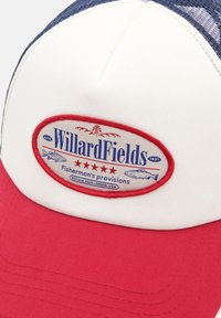 Šoférska čiapka s bielym predkom, červeným brímom a tmavomodrou sieťovinou na zadnej strane. Oválna nášivka obsahuje logo "WillardFields" v modrej a červenej farbe s grafikou ryby.