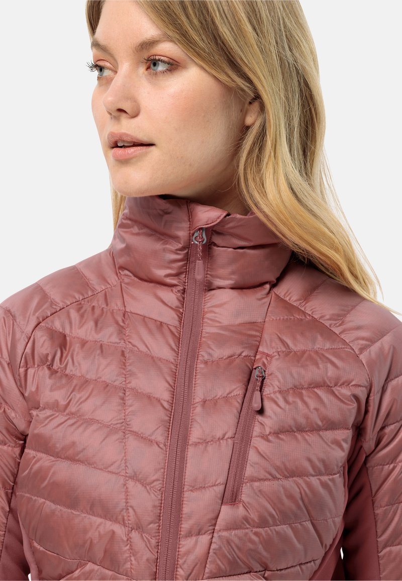 Leichte, gesteppte Jacke in zartem Rosa mit hohem Kragen, Reißverschluss vorne und seitlicher Tasche. Glatte Textur mit dezenter glänzender Oberfläche.