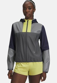 Gray and navy windbreaker jacket with a hood, featuring a yellow chest panel and zippered pockets, made of smooth, lightweight material.