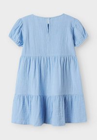 Robe bleu clair avec de courtes manches bouffantes, tissu texturé, ourlet à volants en niveaux et fermeture par bouton à l'arrière au niveau du col.