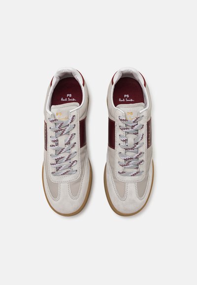 Graue und burgunderfarbene Sneakers mit Akzenten aus Wildleder und Leder. Sie verfügen über graue und rote Schnürsenkel, eine Gummisohle und eine geprägte Branding auf der Seite.