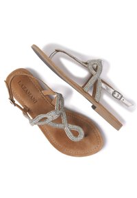 Sandali in suede marrone con un design di cinturini gioiello metallici argento, caratterizzati da un motivo a loop infinito. Chiusura regolabile con fibbia alla caviglia.
