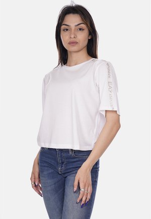 T-shirt bianca cropped in tessuto morbido, con maniche corte e dettagli in rilievo sul branding sulle spalle, dal taglio morbido.