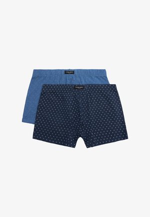 Dos pares de calzoncillos tipo bóxer para hombre, uno azul claro y otro azul marino, ambos con pequeños patrones blancos de anclas y etiquetas de la marca en la cinturilla.