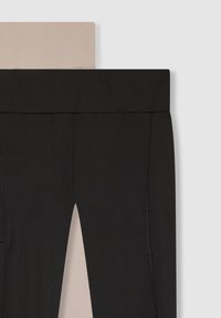 Czarne i cieliste legginsy ułożone razem, z szerokim pasem w talii. Czarne legginsy mają boczne szwy i teksturowane wykończenie. Obie pary są gładkie.