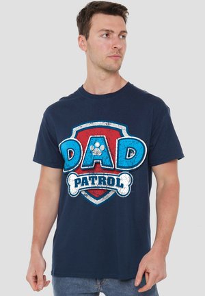 Navy blue cotton t-shirt featuring a large “DAD PATROL” graphic in blue and white, inside a red shield with a paw print and bone accents.