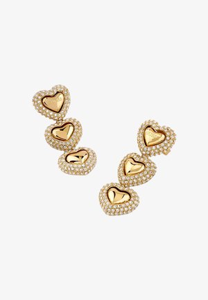 Boucles d'oreilles triple cœur en ton or avec bordures en cristaux, chaque cœur supérieur gravé du nom de la marque "GUESS".
