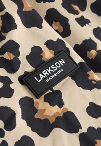 Fekete és barna leopárdmintás anyag, rajta egy fekete, téglalap alakú folt, amelyen fehér, dombornyomott betűkkel az "LARKSON HAMBURG" felirat olvasható.