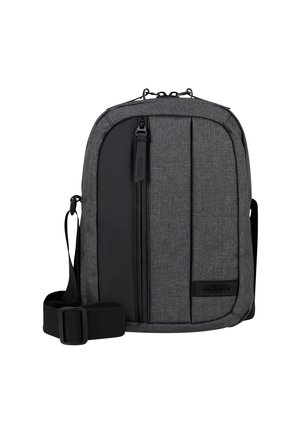 Borsa a tracolla grigia con texture in tessuto, dotata di una tasca anteriore con zipper, tracolla regolabile e accento del logo. Pannello laterale nero liscio.