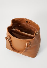 Brown textured leather tote bag with gold hardware, featuring a spacious interior and a zippered pocket. Open top with sturdy handles.