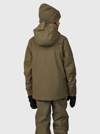 Persona che indossa una giacca con cappuccio verde oliva, pantaloni abbinati, guanti neri e un basco di maglia verde oliva, di spalle su uno sfondo chiaro uniforme.