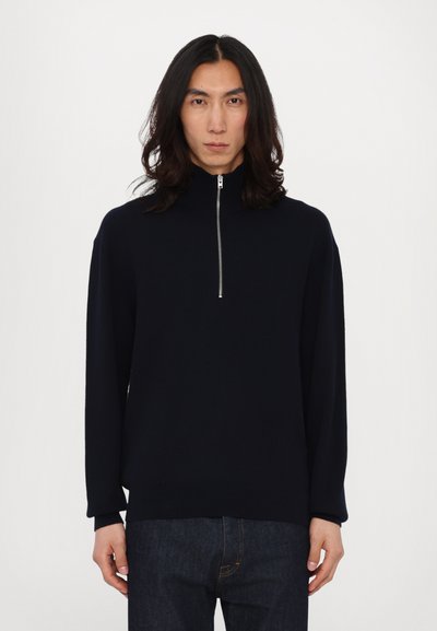 Marineblauer Strickpullover mit hohem Kragen und kurzem Reißverschluss. Lässige Passform mit überschnittenen Schultern und langen Ärmeln. Strukturierter Stoff.