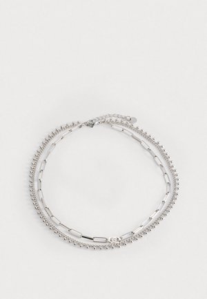 Ezüst karkötő három szálból: az egyik kis gyöngyökkel, a másik ovális láncszemekből, a harmadik lapos rudakból készült. Hosszabbító lánccal rendelkezik a méretállításhoz.