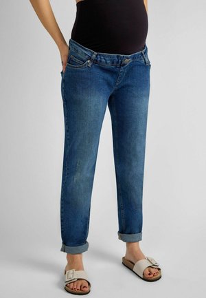 Denim teksapüksid, keskmiselt sinine värv, mugav lõige rullitud lapidega, viis taskut, nupuga kinnitamine, kulunud kohad põlvedel, sile tekstuur.