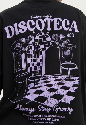 Chemise noire avec scène disco lavande featuring des chérubins, une boule disco, un sol de danse à damier, des tables et le texte "Discoteca 80’s" et "Always Stay Groovy."