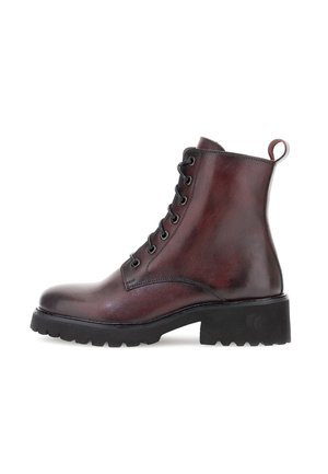 Dark brown leather lace-up ankle boot with chunky black treaded sole and pull tab on white background.