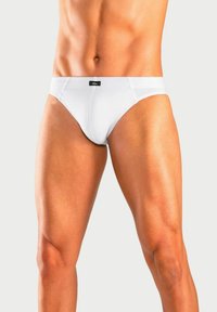Weiße Baumwollslips mit einem taillierten Design, das einen auffälligen Bund und einen minimalistischen Stil aufweist. Glatte Textur und schlichte Schnittführung.