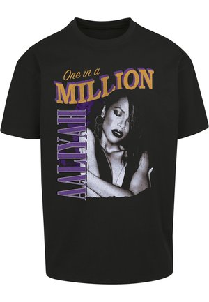 T-shirt di cotone nero con una stampa grafica del ritratto di una donna, con il testo "One in a Million" in viola e oro, posizionato verticalmente.