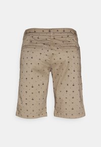 Béžové šortky s opakujícím se černým vzorem palmových stromů a symbolů, se dvěma zadními kapsami a rovnou spodní částí.