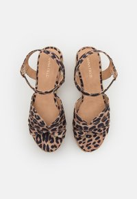 Sandales à plateforme en imprimé léopard avec un design à bride croisée, de couleur beige, texture douce et sangle de cheville réglable pour un maintien sécurisé.