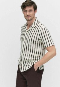 Korte mouwen shirt in crèmekleur met een donkerbruine zigzagpatroon, met een ingelegd kraag en een relaxed fit. Gemaakt van een gestructureerde stof.