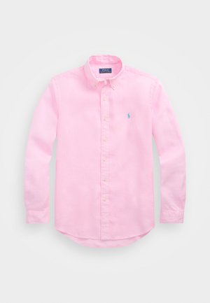 Svetloružová košela na gombíky z bavlny, s golierom, dlhými rukávmi a malým modrým logom na prsiach. Mäkka textúra.