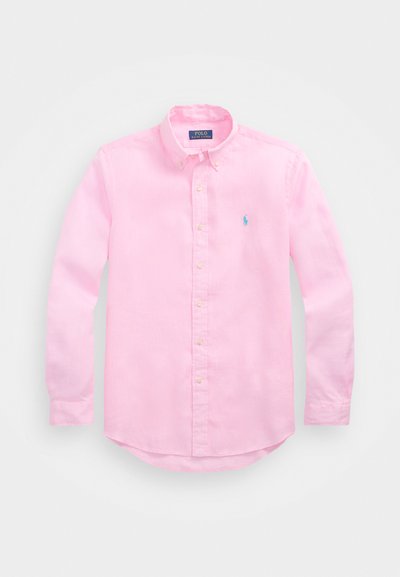 Light pink button-down shirt made of cotton, featuring a collar, long sleeves, and a small blue logo on the chest. Soft texture.