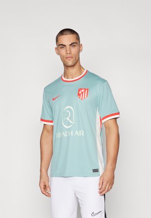 Lichtblauw voetbalshirt met rode accenten op de mouwen en de kraag. Bevat het logo van Atlético Madrid en het sponsorlogo op de voorkant.