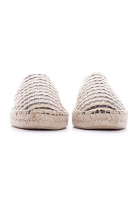Espadrilles de tela trenzada con un patrón beige y negro, que cuentan con una suela de yute y un diseño transpirable para un uso informal.