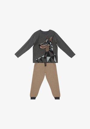 Langærmet mørkegrå skjorte med geometrisk Doberman-hundedesign kombineret med beige joggingbukser med manchetter ved anklerne og snøre i taljen.