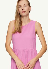 Hellrosa ärmelloses Kleid aus strukturiertem Stoff, mit rundem Ausschnitt und gerafftem Bund, das eine lässige Passform und einen subtilen Glanz bietet.