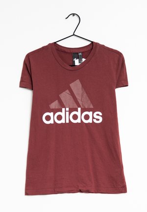 T-shirt en coton bordeaux à manches courtes, col rond, avec un grand logo "adidas" blanc et trois bandes imprimés à l'avant. Accroché à un crochet.