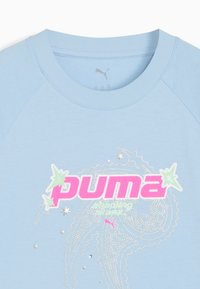 Sudadera de manga corta azul claro con mangas raglán, que presenta un logo de "Puma" en rosa y adornos de estrellas plateadas en un diseño divertido.