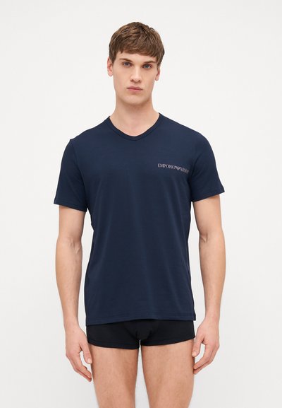 Navy blue cotton t-shirt with short sleeves and a v-neck. Features a small, white Emporio Armani logo on the left chest area.