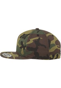Barna és zöld álcázó snapback sapka lapos bőrrel, szövettextúrával és varrott részletekkel a korona és a napellenző felületén.