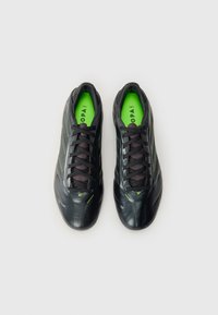 Black athletic shoes with a smooth leather finish. Features vibrant green accents, a textured mesh tongue, and black laces.