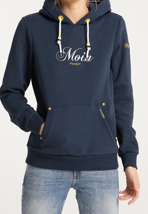 Sudadera azul marino con bolsillo canguro, cordones y detalles amarillos. Presenta el texto blanco "Moin" en la parte delantera. Tejido suave y texturizado.