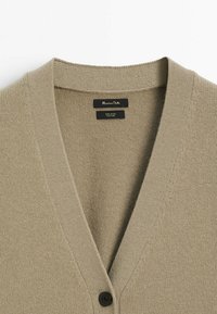 Beige wool cardigan with a V-neck, two buttons, and textured fabric. Label reads "Massimo Dutti" and "100% wool."