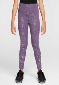 Leggings morados con una cintura alta, que presentan un patrón plateado moteado. Hechos de un material elástico, combinados con zapatillas deportivas negras.