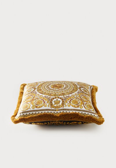 Τετράγωνο διακοσμητικό μαξιλάρι με περίπλοκο κίτρινο και χρυσό λουλουδένιο μοτίβο, λευκό φόντο και υφασμένη καφέ διακόσμηση περιμετρικά.