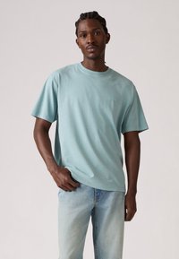 Lysblå bomulds t-shirt med rund hals og korte ærmer, med et lille logo på brystet og en afslappet pasform.