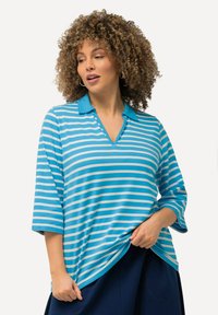 Top a righe blu con colletto polo e scollo a V, dotato di maniche a tre quarti e vestibilità ampia. Il tessuto appare liscio con una consistenza leggera.