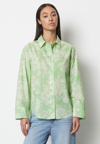 Camicia button-up verde chiaro con un motivo floreale in bianco. Presenta un colletto a punta e maniche lunghe, realizzata in un tessuto morbido.