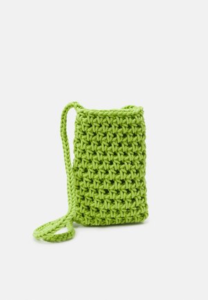 Bolso pequeño de ganchillo verde brillante con una correa gruesa trenzada y un patrón de puntada texturizada sobre un fondo blanco.