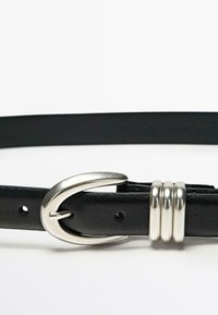 Zwarte leren riem met een zilveren metalen gesp met een gebogen ontwerp. Verhoogd met drie zilveren ringen. Glad textuur, klassieke vorm.