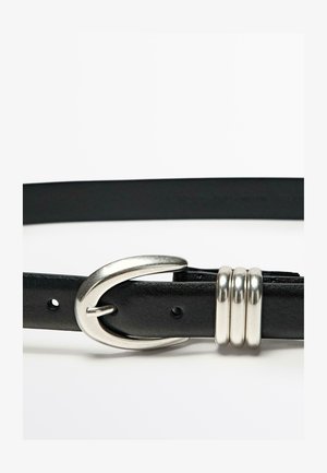 Schwarzlederner Gürtel mit einer silbernen Metallschnalle mit geschwungenem Design. Akzentuiert mit drei silbernen Ringen. Glatte Textur, klassiche Form.